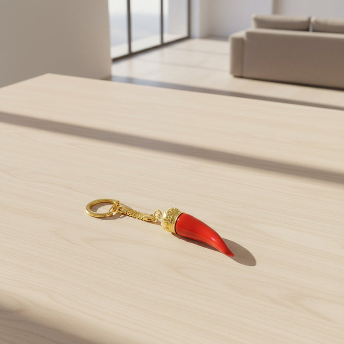 Red keychain with gold crown and gold ring on a white background