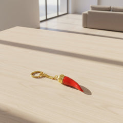 Red keychain with gold crown and gold ring on a white background