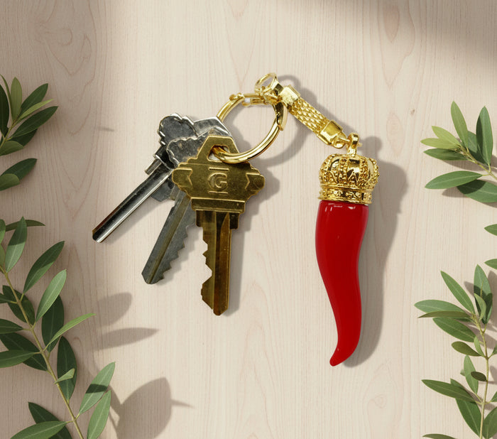 Keychain with red horn and gold crown on a white background