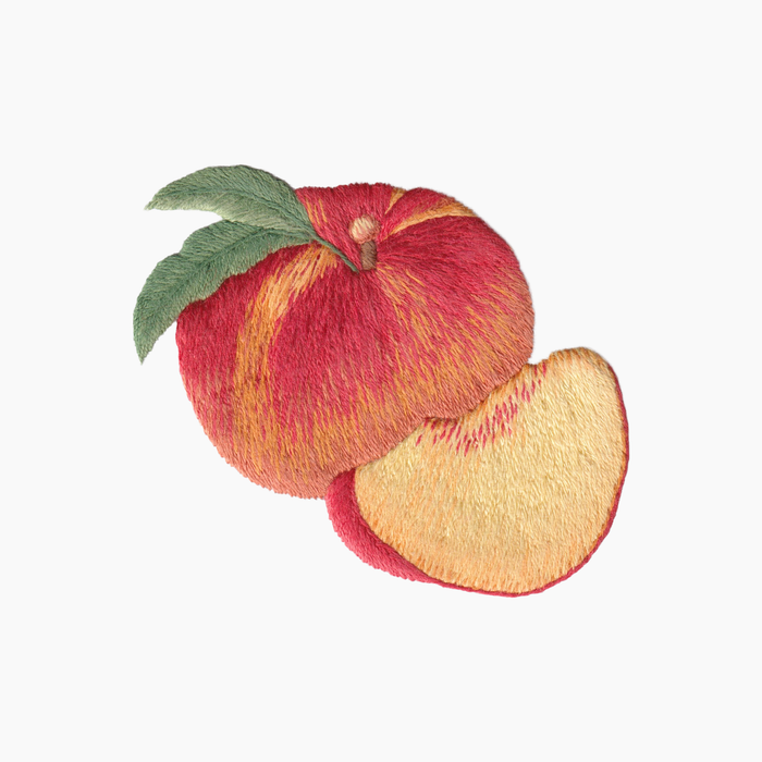 Hand embroidered cotton towel with red and yellow peach with a green leaf on a white background