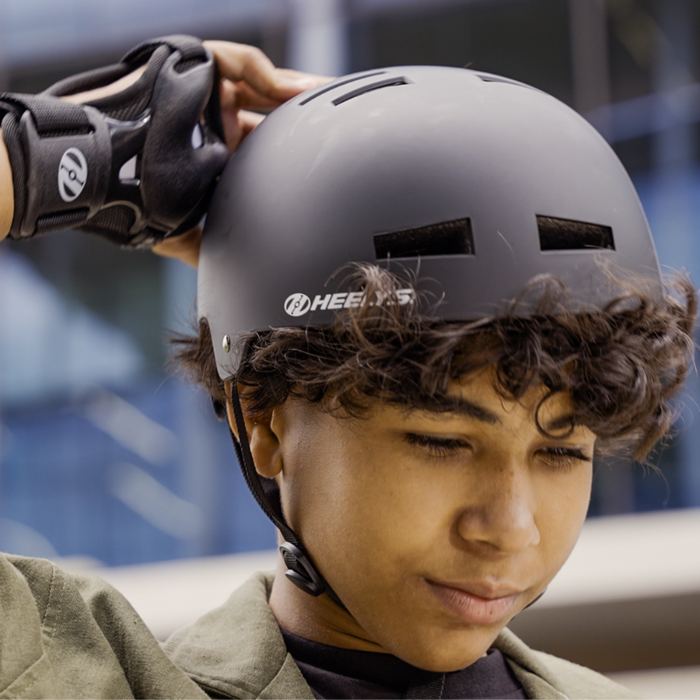 Child wearing a helmet and knee pads in an urban setting