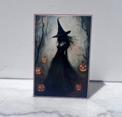 Witch silhouette surrounded by glowing jack-o-lanterns canvas print