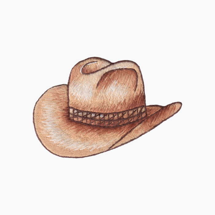 Hand embroidered cotton towel of a brown cowboy hat on a white background