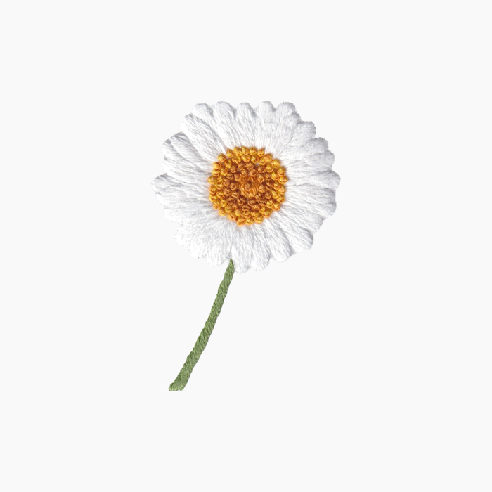 Hand embroidered cotton boutique tissue box cover of white daisy flower with a yellow center and green stem on a white background