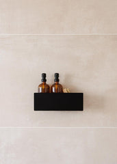 Duschablage SHEA mit zwei Flaschen auf einem stilvollen schwarzen Regal in der Dusche
