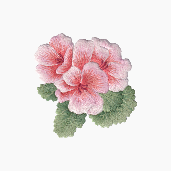 Hand embroidered cotton towel with pink geranium flower with green leaves on a white background