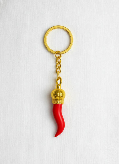 Red keychain with gold accents on a white background