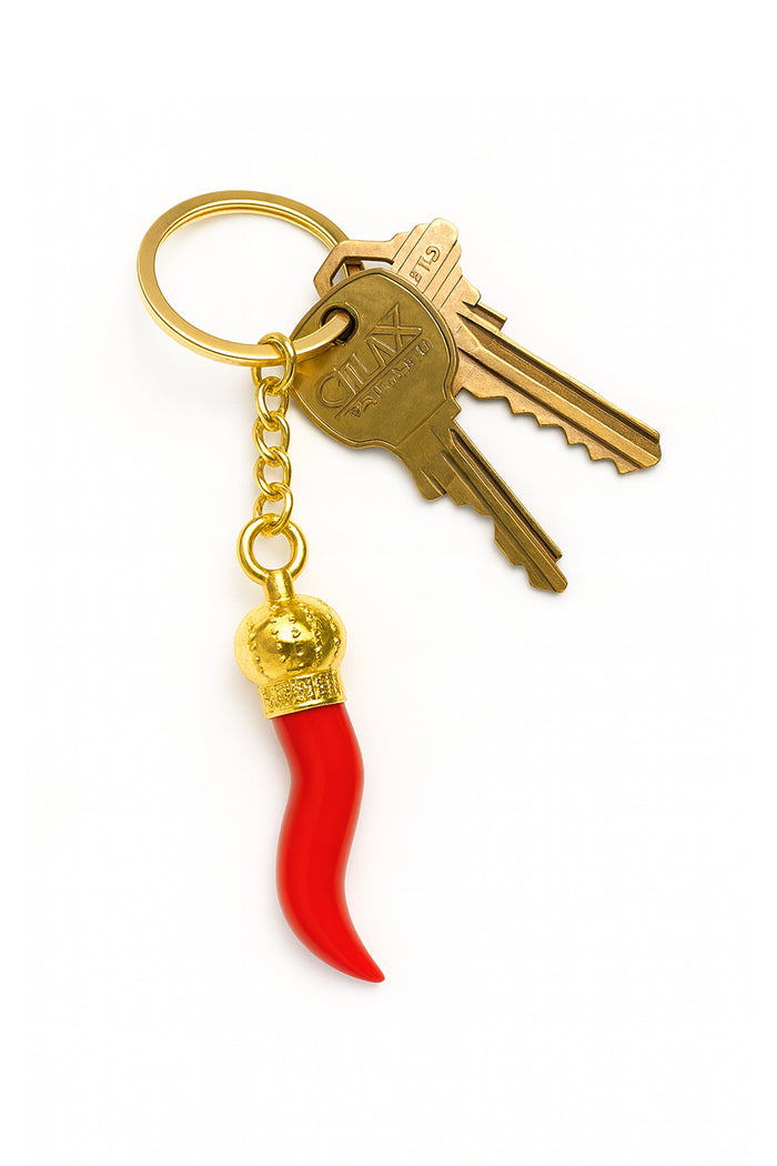 Keychain with red chile pepper charm and gold accents on a white background