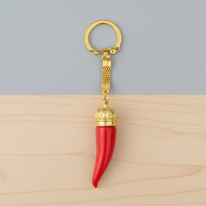 Red keychain with gold crown and gold ring on a white background